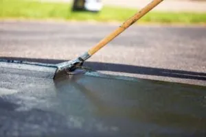 professional contractor sealcoating asphalt driveway